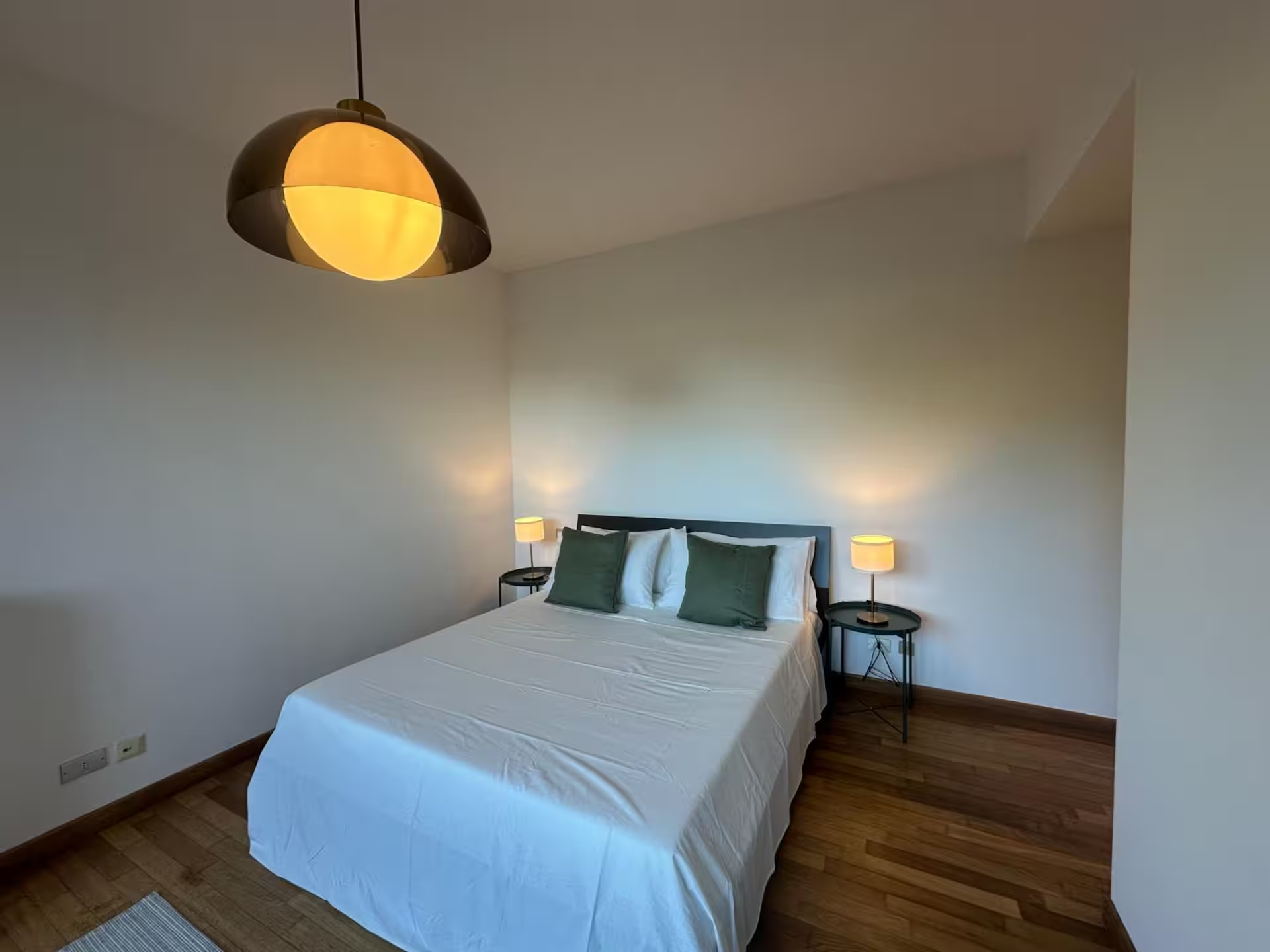 Serene master slaapkamer met houten hoofdeinde, toegang tot het terras en zachte sfeerverlichting