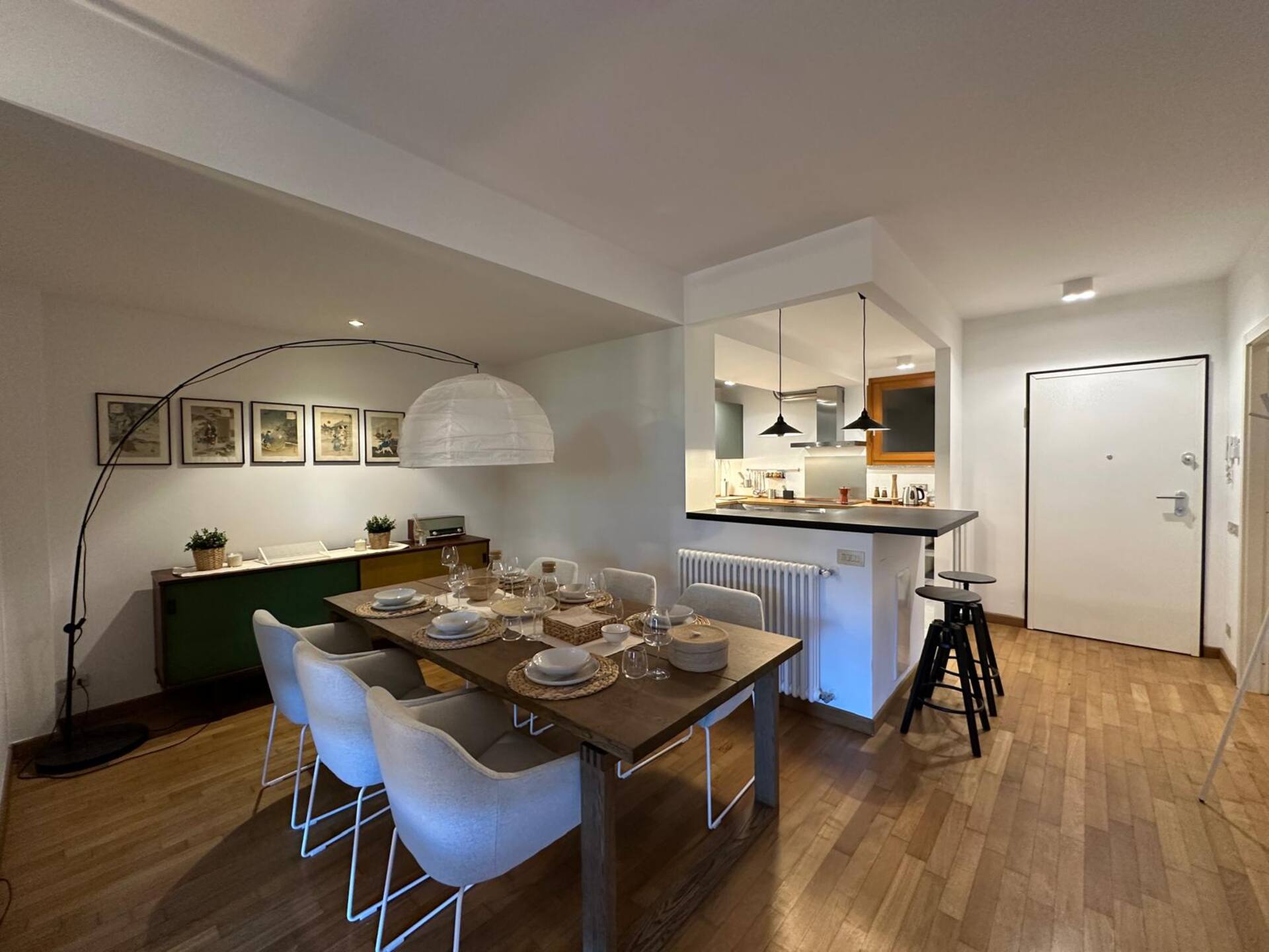 Eigentijdse slaapkamer met opvallende hanglamp, bosgroene accenten en hardhouten vloer