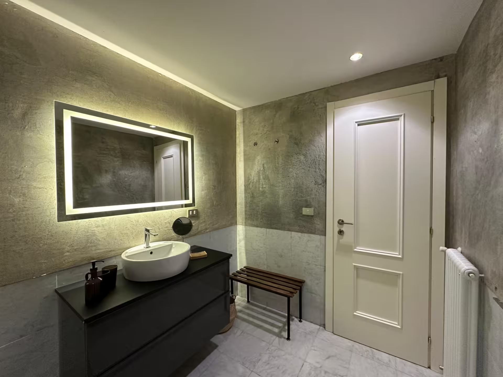 Open eetgedeelte met opvallende booglamp, moderne stoelen en een gecureerde kunstcollectie